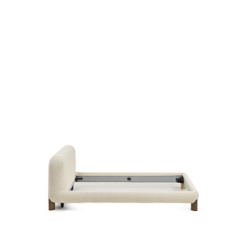 Lit Odina avec housse amovible en bouclé écru et pieds en frêne massif finition noyer certifié FSC, pour un matelas de 180 x 200 cm